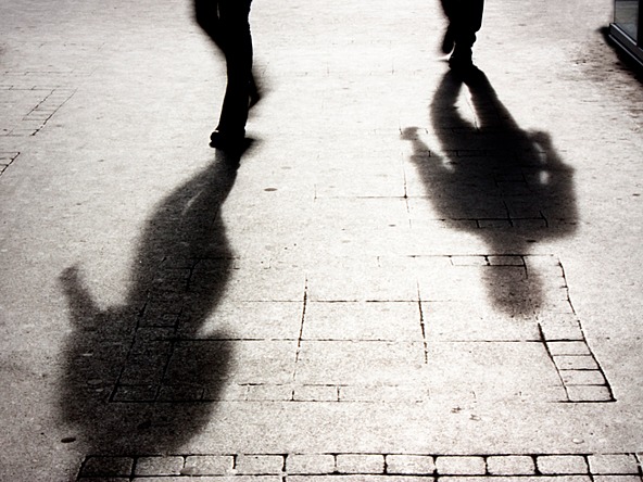 dark shadows of people walking on street